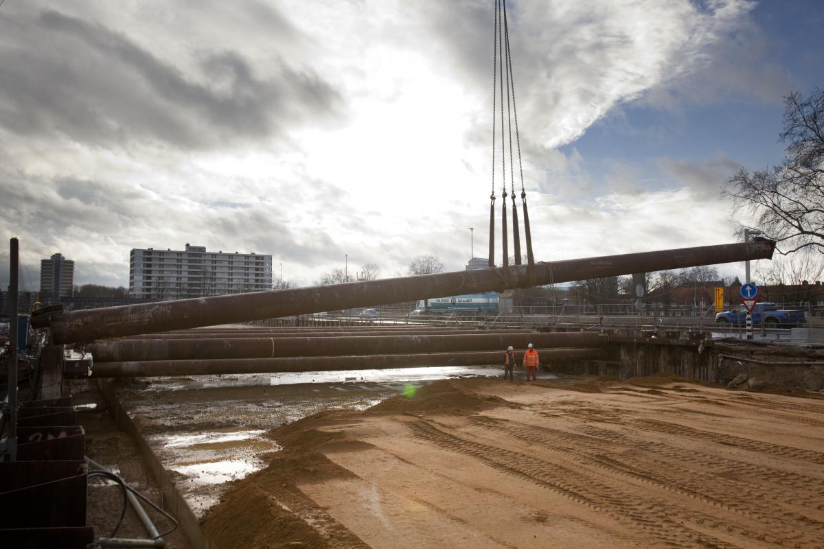 Een stalen buis wordt aan een kraan in de bouwkuip van de A2 in Maastricht gehesen