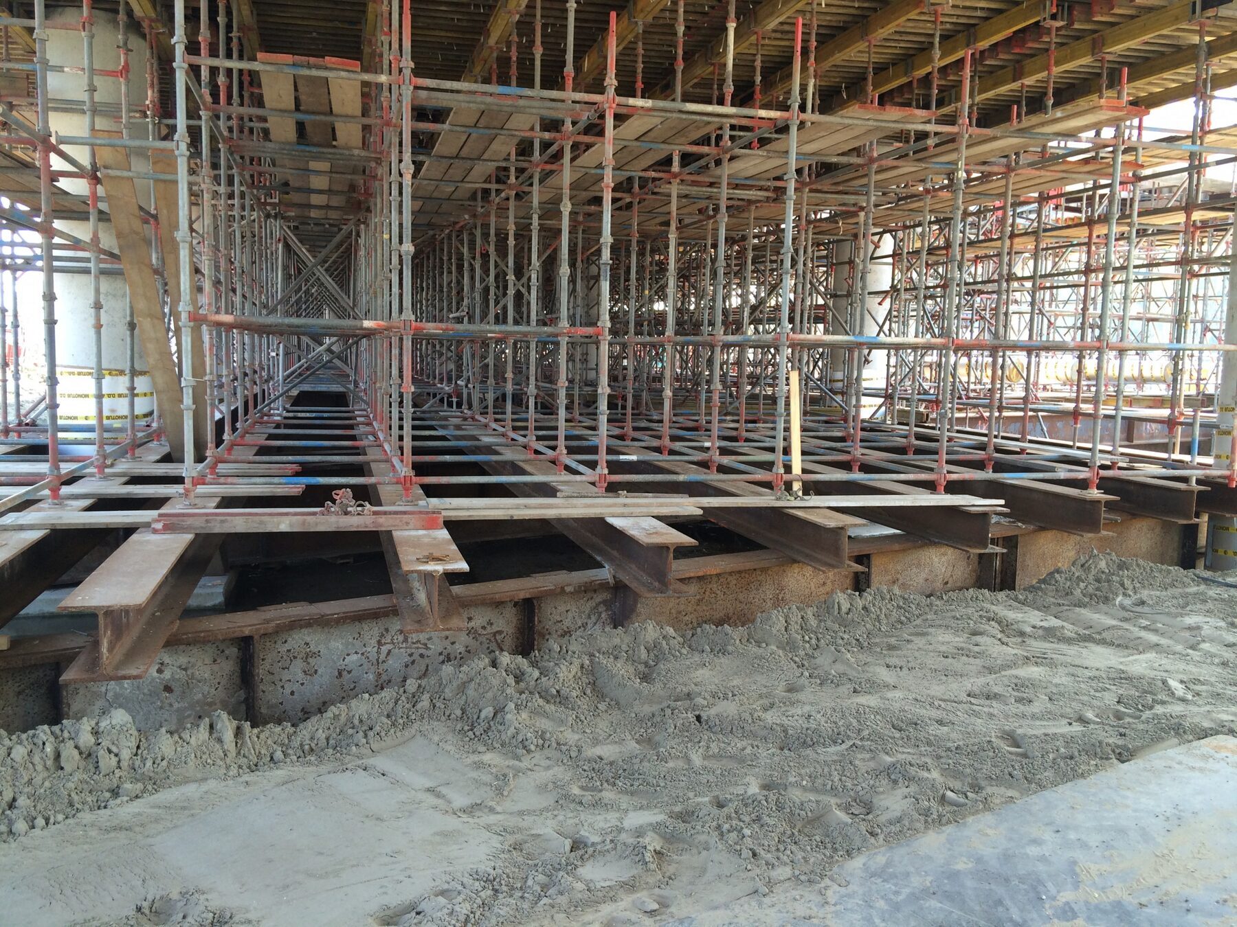 Een stalen draagconstructie met steigerwerk op een bouwplaats